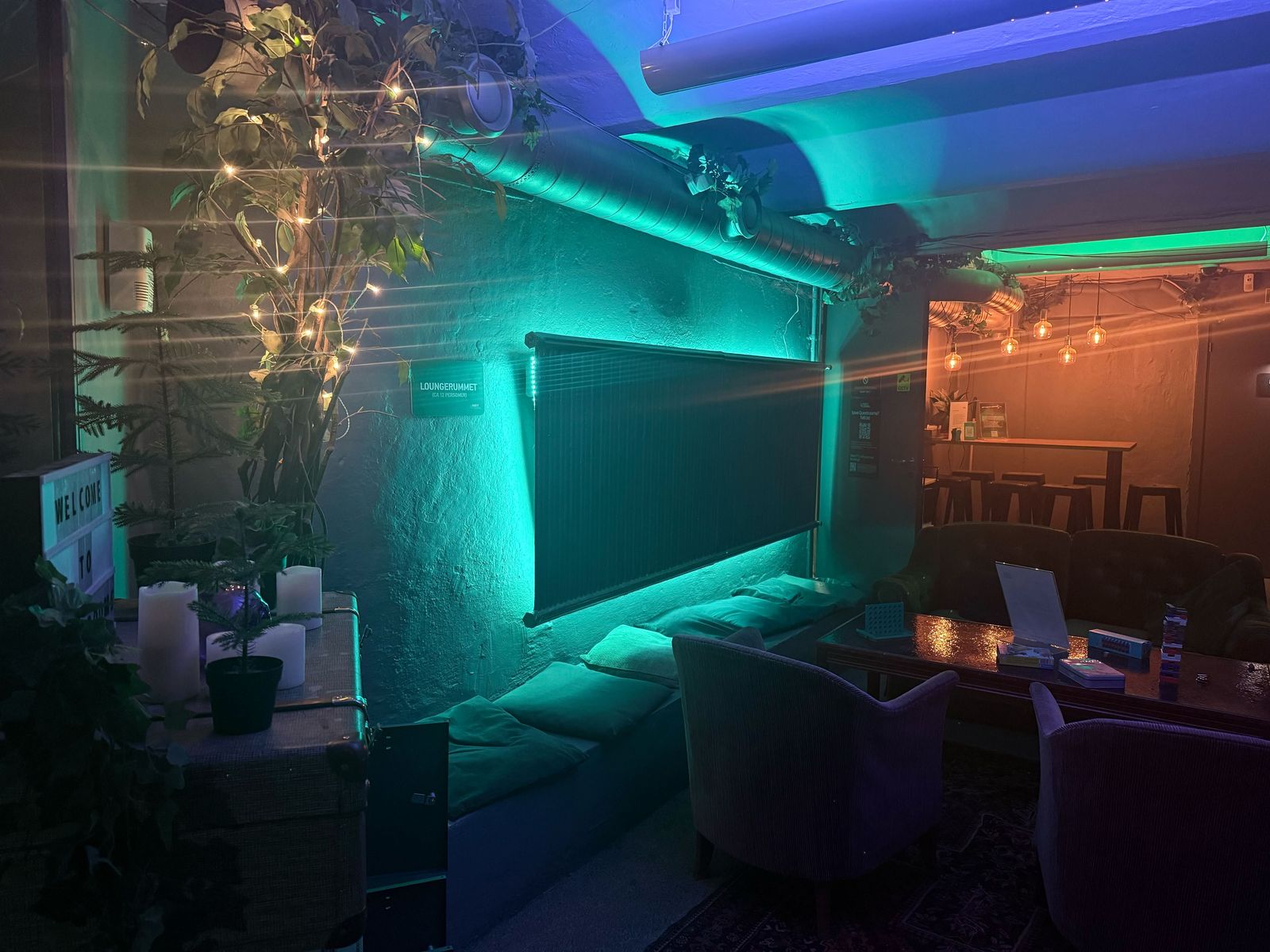 The lounge room with a bench and armchairs, and the high table with bar stools further in