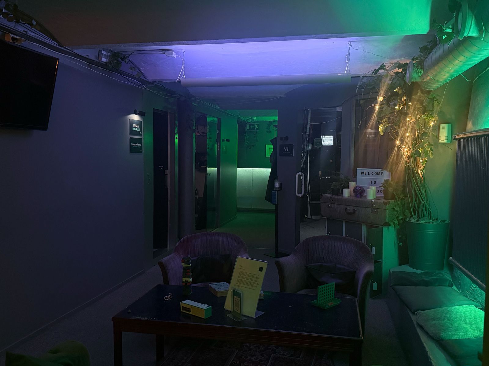 The lounge with armchairs, board games on the table and fairy lights